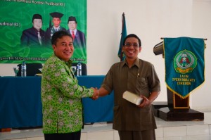 Dr. H. Taufiqurrahman Syahuri, SH., MH menyerahkan cinderamata kepada Dr. H. Sumanta, M. Ag.