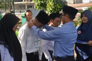 Warek II Dr. H. Adib, M. Ag mengenakan Tanda Peserta secara simbolis kepada peserta Kuliah Ta'ruf sebagai tanda dimulainya acara ta'aruf tahun 2015.